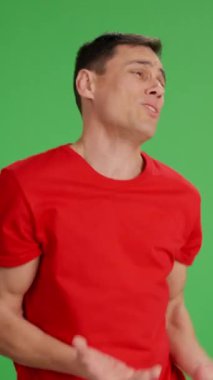 Yeşil ekrandaki sabırsız adam birinin acele etmesini ve fotokopi odasına bakmasını istiyor. Orta boy, kırmızı tişört ve yeşil krom anahtar arka plan