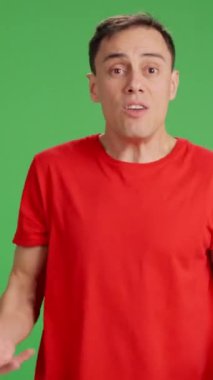 Yeşil ekrandaki sabırsız adam birini acele ettirmeye çalışıyor. Orta boy, kırmızı tişört ve yeşil krom anahtar arka plan
