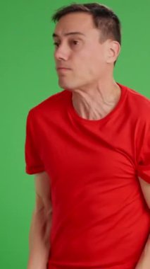 Kırmızı tişörtlü adam pişmanlığını dile getiriyor ve yeşil ekranlı birinden af diliyor.