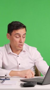 Çalışan masasında çeşitli seviyelerde tükenme yaşıyor ve yeşil ekran arka planında izole bir şekilde klavyede uyuyakalıyor.