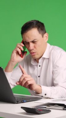 İşadamı masasında çalışırken telefonda tartışıyor, yeşil ekranda tek başına.