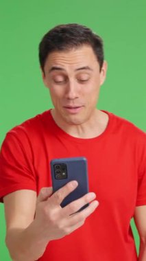 Video görüşmesi için akıllı telefonu kullanan, konuşan ve yeşil ekranda el kol hareketi yapan mutlu adam.