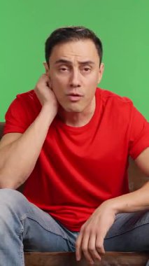 Televizyonda maç seyreden coşkulu bir adam, takımının zaferini yeşil ekran arka planında kutluyor.