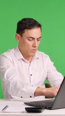 Çalışan bir dizüstü bilgisayar üzerinde çalışırken büyük bir hata yapıyor ve bundan pişmanlık duyuyor, yeşil ekranda izole edilmiş.