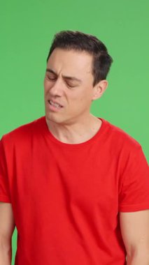 Mutluluktan üzüntüye, yeşil ekranda çeşitli duygular ifade eden bir adam.