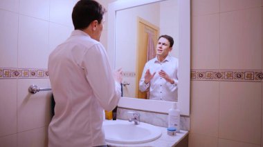 İş adamı, konuşmasını banyo aynası önünde yapıyor, bir sunum ya da halka açık bir konuşma için hazırlanıyor.