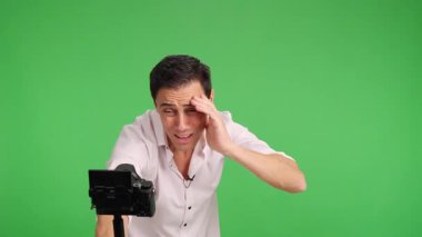Mutluluk içeriği yaratıcısı yeşil ekran arka planında bir video blogu kaydederken şok edici ve heyecan verici haberler paylaşıyor