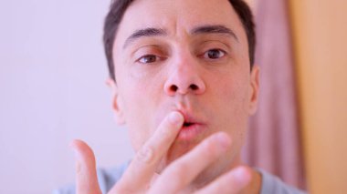 Adam çatlamış dudaklarını kakao yağıyla nemlendiriyor, tuvalette cildine bakıyor.