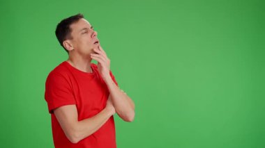 Kırmızı tişörtlü sıkıcı adam esniyordu ve neredeyse uyuyakalıyordu. Sohbet etmeye çalışır ama yeşil ekran arka planında sıkılır.