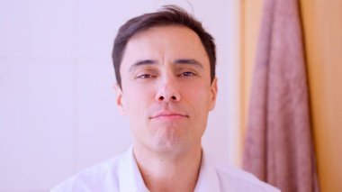 Kendine güvenen işadamı banyoda aynaya bakarken gülümsüyor, işe hazırlanıyor.