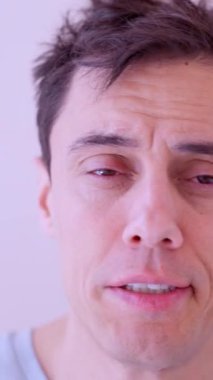 Yorgun adam, iş gününün başlamasından korkarak, yüzünü banyoda isteksizce yıkar.