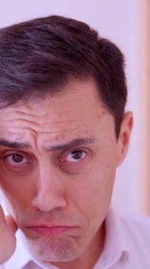 Ofis çalışanı yüzüne parfüm sürüyor ve kokusundan zevk alıyor.