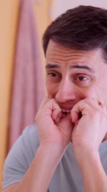 Banyodaki aynanın önünde diş ipi kullanan adam günlük ağız temizliği rutini uyguluyor.