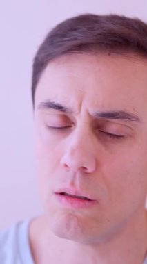 Kötü soğuk algınlığı geçiren ve burnunu mendille silen bir adam.