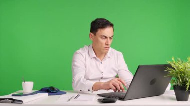 Ofis çalışanı sinirleniyor ve sinirleniyor çünkü bilgisayar çöktü ve hata yapıyor. Yeşil ekran arkaplanı.