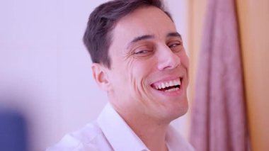 Kendine güveni olmayan bir adam aynanın önünde selfie çekmeye çalışır ama iyi görünmez.