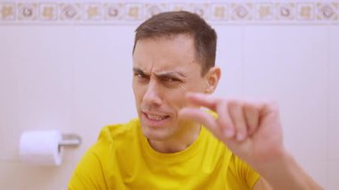 Tuvalette oturan adam, onun için boşaltmanın ne kadar kolay olduğu konusunda gururlu ve mutlu.