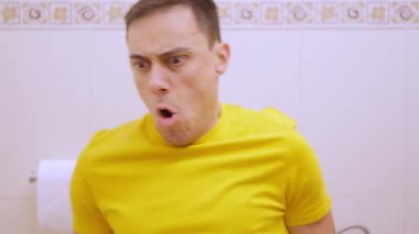 Sindirim sorunu olan bir adam tuvalette oturuyor ve çok fazla tuvalet kağıdı kullanıyor. Komik.