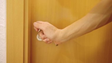 Adam banyo kapısını açar, içeri girer ve kapatır.