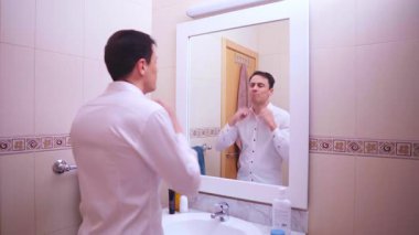 İş adamı aynada kendine bakıyor, giyiniyor ve önemli toplantıdan önce kendini motive ediyor.