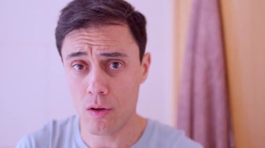 Taze nefes ve ağız temizliği için ağız gargarasıyla gargara yapan bir adam.