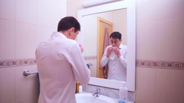 Hasta bir çalışan banyo aynasında çalışmaya hazırlanıyor.