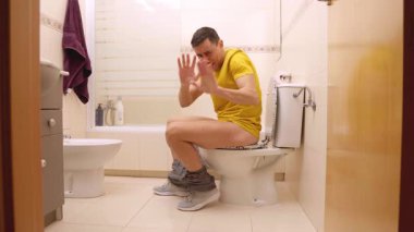 Tuvalette oturan, kendinden emin ve gururlu bir adam.