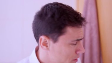 Ofis çalışanı yüzüne parfüm sürüyor ve kokusundan zevk alıyor.