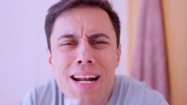 Banyodaki aynada diş fırçasını mikrofon olarak kullanan komik adam şarkı söylüyor.