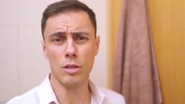 Narsist bir adam saçını tarıyor ve aynanın önünde komik suratlar yapıyor.