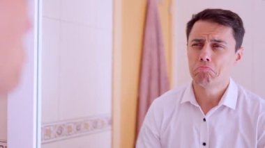 İş adamı parfüm sıkıyor, aynanın karşısında hazırlanıyor.