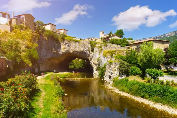 İspanya 'daki Nela nehri boyunca uzanan doğal bir kaya kemerinin üzerindeki Puentedey köyü evleri