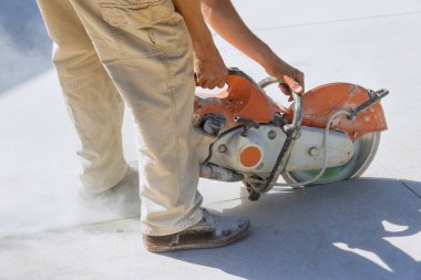 Bu inşaat işçisi kaldırımlar için beton kaplama kesiyor. Elmas bıçaklı testereyle kesilmiş..