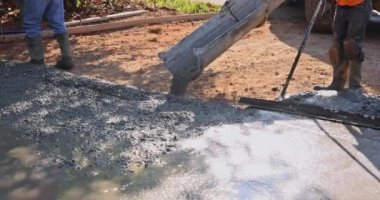 İşçi müteahhit beton dökerken beton inşaatının kaldırımlarını döktü