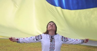 Ukraynalı genç bir kadının Ukrayna bayrağını elinde tutup cennete gitmesi için dua ediyor..