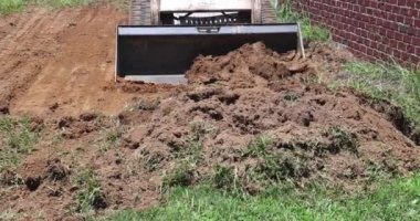 Manzara buldozer gibi çalışıyor. Toprağı hareket ettirmek için kepçe kullanıyor.