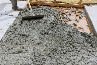 Otopark için beton yollar inşaat alanında çalışan bir işçi tarafından dökülüyor.