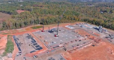 Yüksek binaların inşaat sahasında çalışan vinçlerin havadan görüntüsü