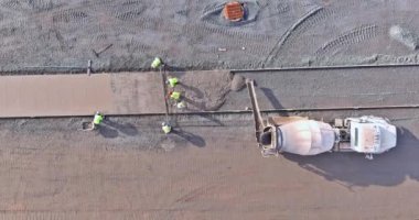 İnşaat alanındaki kaldırım işçilerine beton döken çimento kamyonu.
