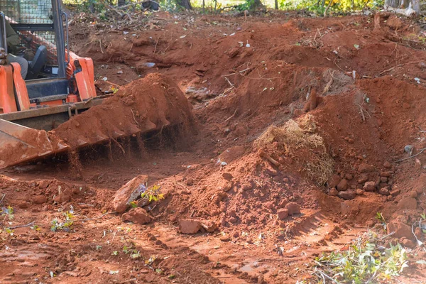 stock image Small tractor is used to move soil on construction site to be used as landscaping material