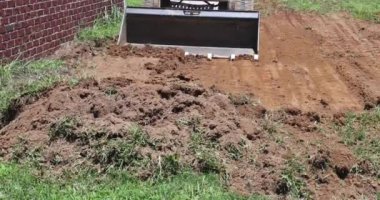 Peyzaj işleri için buldozer kullanmak, toprağı hareket ettirmek için kepçelemek.