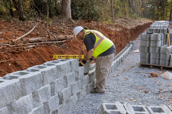 stock image An employee of construction company is building retaining wall on property which is being built