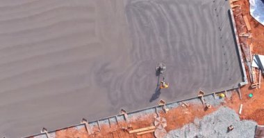 İnşaat alanında çimento kaplı havan zemini parlatılıp düzleştirilirken,