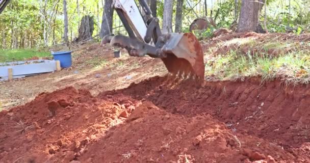 建設現場での土盛り作業中にクローラショベル彼らの爪の掘削機を使用して地球のバケツを掘る — ストック動画