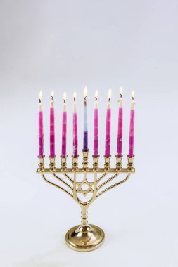 Menorah Hanuka festival sembollerinde beyaz arkaplan kopyalama alanı ile aydınlatılmış tatil sembollerini mumlar
