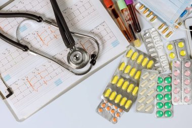 Kalp kardiyogramı steteskop ve bir sürü ilaç şişliği olan kardiyo doktoru ofisi.