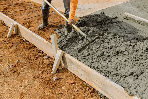현장에서 일하는 사람들 추가로 보도를 만들기 시멘트를 붓는다 — 스톡 사진
