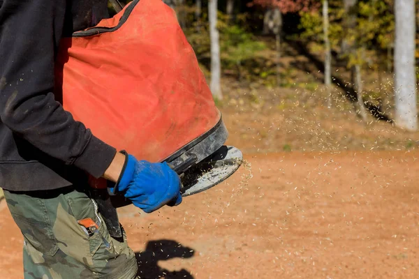 stock image Using seeding device, landscapers gardeners work together to sow lawngrass seed