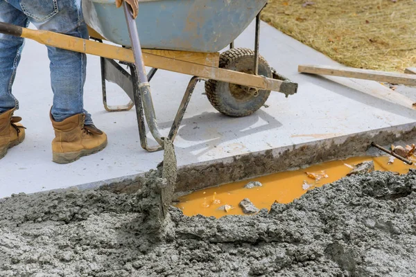 Bir çalışan, araba için park yerine beton döker.