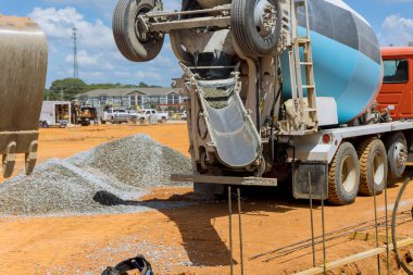 Karıştırıcı kamyonu inşaat alanına ıslak çimento döküyor.